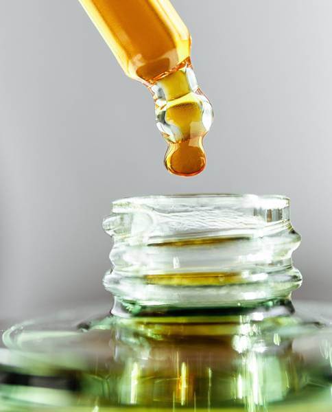 CBD dropper dripping a drop into a bottle